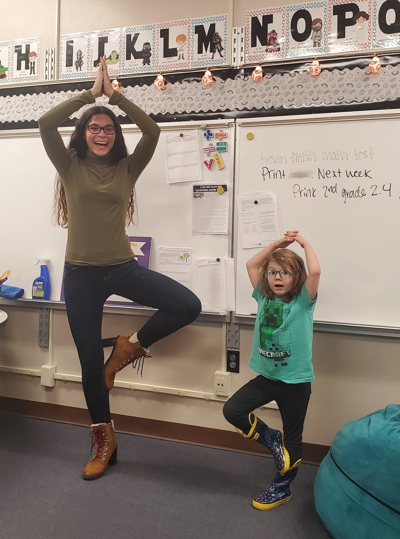 Ms. Kerestes and Kaylie Sabo practice yoga moves they learned in the book