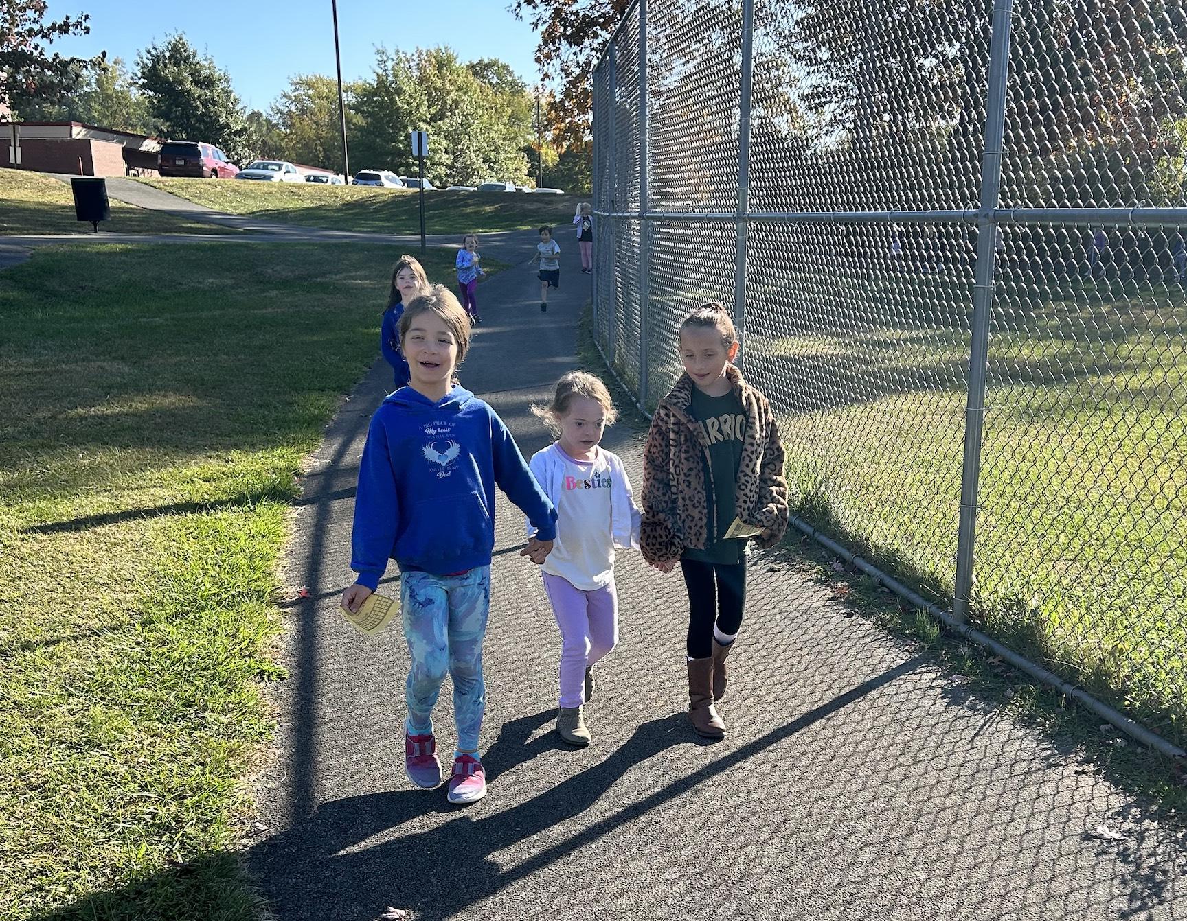 First-graders Olivia Weisend, Charlotte Teoli, and Gemma Armbrust enjoy the brisk walk